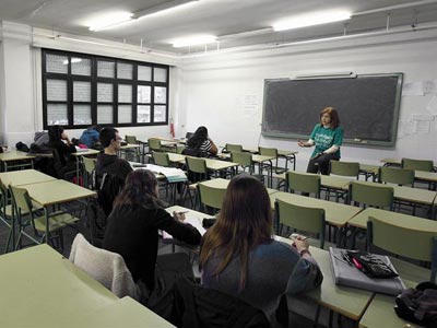 Una profesora imparte clase en aula prácticamente vacía, en el instituro Juan de la Cierva de Madrid. EFE/ Ángel Díaz