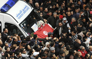 Manifestantes tunecinos rodean la ambulancia donde se encuentra el cadáver del líder opositor Chukri Bel Aid.