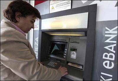Una mujer saca dinero ayer de un cajero automático en Nicosia, Chipre.