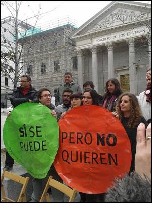 Miembreos de la PAH y la Asamblea de Vivienda de Madrid posan con los nuevos carteles para su campaña ante el Congreso de los Diputados.