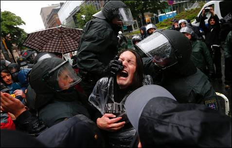Los policías tratan de reducir a uno de los manifestantes concentrados delante de la sede del BCE.