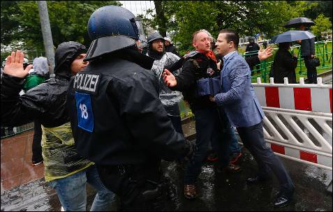 Un empleado que trabaja en el distrito financiero de Fráncfort se enfrenta a algunos de los manifestantes concentrados delante de la sede del BCE.