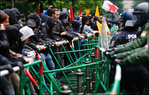 Los manifestantes tratan de levantar la barrera colocada por la policía alemana en torno a la sede del BCE en Fráncfort.
