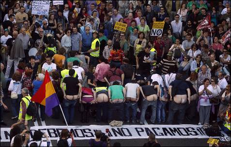 Varios manifestantes se bajan los pantalones durante la manifestación contra la troika en Madrid.