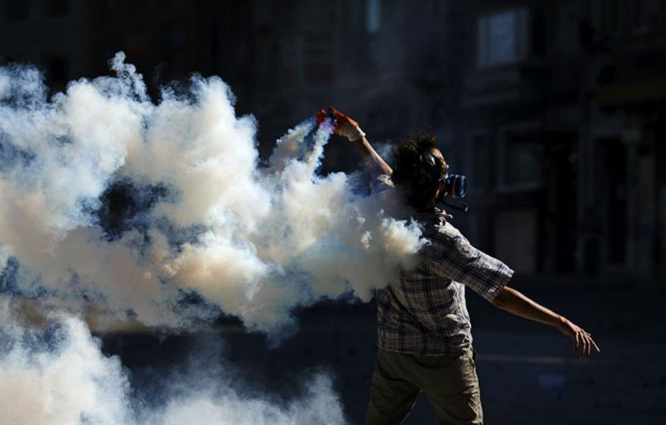 Un manifestante lanza un bote de gas lacrimógeno durante un enfrentamiento contra la policía antidisturbios en la Plaza Taksim de Estambul.