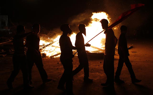 Un grupo de manifestantes camina junto a los restos de una barricada en llamas, durante una nueva noche de enfrentamientos (12 junio)- REUTERS/Murad Sezer