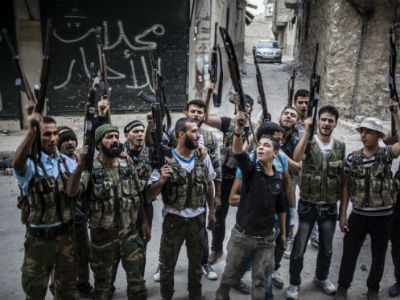 Rebeldes sirios levantan sus armas frente a un edificio destruido. -EFE