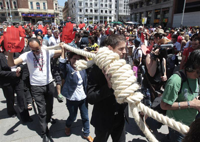 Una procesión con personas unidas por una soga, en la plaza de Callao de Madrid, cierra simbólicamente el V Congreso Mundial contra la Pena de Muerte.