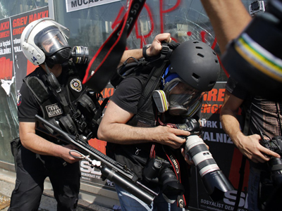 Un fotógrafo es agredido por un policía antidisturbios en la plaza Taksim de Estambul.