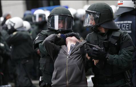 La Policía detiene a una manifestante durante la concentración frente al BCE en Frankfurt organizado por el movimiento Blockupy.