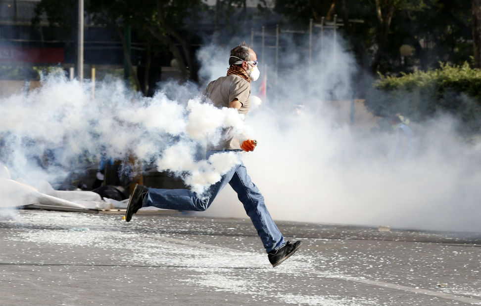 Un indignado turco corre para escapar de una lata de gas lacrimógeno.