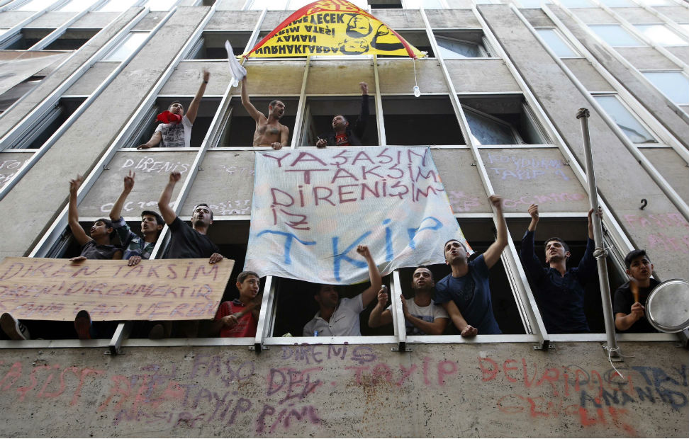 Los indignados turcos gritan consignas contra Erdogan desde las ventanas de un edificio en Estambul.