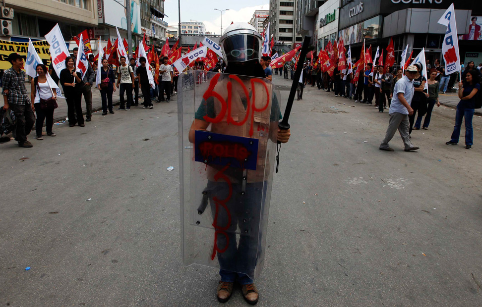 Un manifestante, fotografiado con un casco, un escudo y una porra de policía antidisturbios, en Ankara.