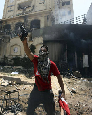 Un opositor sostiene una pistola presuntamente utilizada por miembros de los Hermanos Musulmanes e incautada en un asalto a su sede principal en al-Moqattam, en el Cairo.