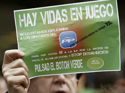 Un hombre sostiene un cartel con el lema 'Hay vidas en juego' durante una concentración de la PAH. -EFE
