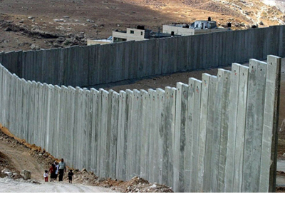 Una familia palestina camina junto a un muro en Cisjordania. EFE