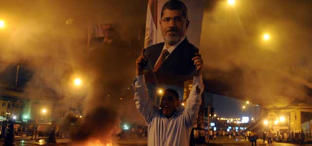 Un manifestante sostiene una fotografía del expresidente Mursi en la plaza Ramsés el lunes 15 de julio de 2013, en El Cairo (Egipto).EFE/KHALED ELFIQI