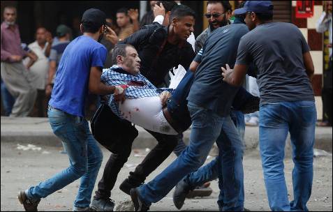 Un grupo de partidarios del depuesto presidente egipcio Mohamed Mursi llevan a uno de los manifestante herido durante los enfrentamientos en la plaza Ramses de El Cairo.