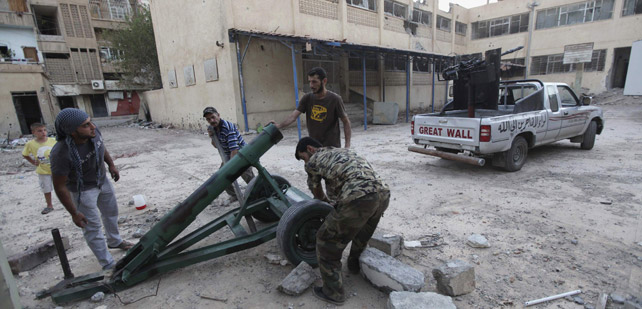 Milicianos rebeldes preparan un mortero para atacar al Ejército
sirio en Deir al Zor. REUTERS/Khalil Ashawi