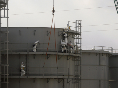 Trabajadores de TEPCO construyen tanques de agua protegidos con trajes y máscaras en la central de Fukushima, en febrero de 2012. REUTERS/Issei Kato