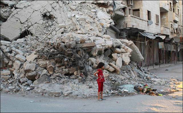 Una niña espera a sus familiares ante las ruinas de un edificio en Idlib tras los bombardeos del régimen.- Reuters