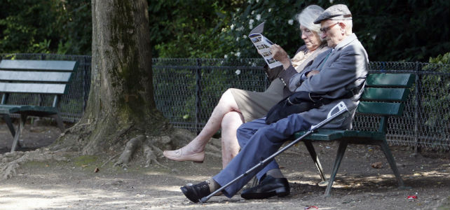 Dos ancianos descansan en el banco de un parque. -REUTERS