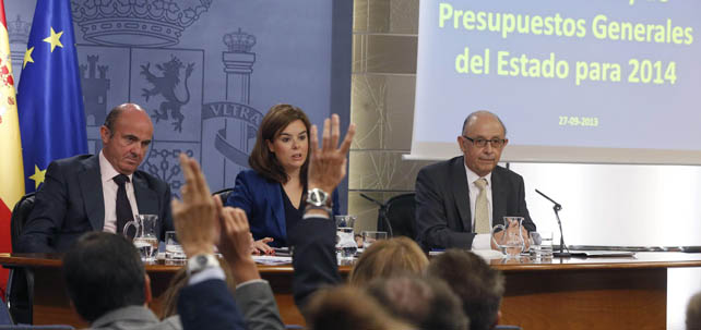 Los ministros de Economía y de Hacienda, Luis de Guindos y Cristóbal Montoro, con la vicepresidenta Soraya Sáenz de Santamaría, en la rueda de prensa tras el Consejo de Ministros en el que se han aprobado los Presupuestos del Estado para 2014.