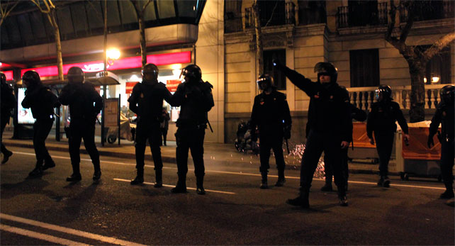 Agentes antidisturbios se disponen a cargar contra los manifestantes en la sede nacional del PP en la calle Génova de Madrid tras una manifestación de apoyo a la protesta de Gamonal, en Burgos.