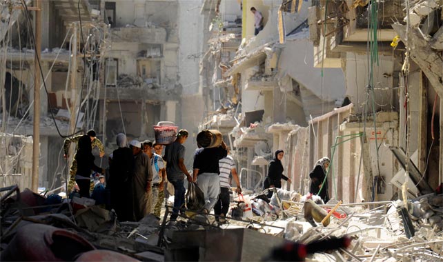 Habitantes de damasco recuperen enseres personales entre los restos de varios edificios destruidos.