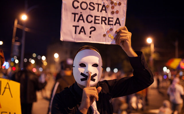 Un manifestante en una protesta en Bucarest con un el cartel que reza: '¿cuánto vale tu silencio?' Apela a aquellos que no protestan ni votan.