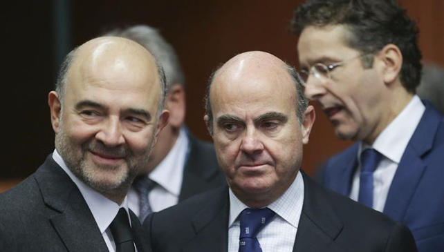 El ministro español de Economía y Competitividad, Luis de Guindos (d), junto al comisario europeo de Asuntos Económicos, el francés Pierre Moscovici, al inicio de la reunión de los ministros de Economía y Finanzas de la Unión Europea (UE), en Bruselas