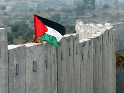 Una bandera ondea sobre el muro de Cisjordania