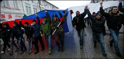 Un grupo de crimeos marchan por Simferópol con una bandera rusa gigante.