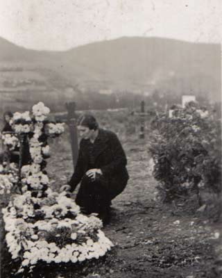 Una mujer junto a una tumba del cementerio de Mondoñedo. MIGUEL FREIRE