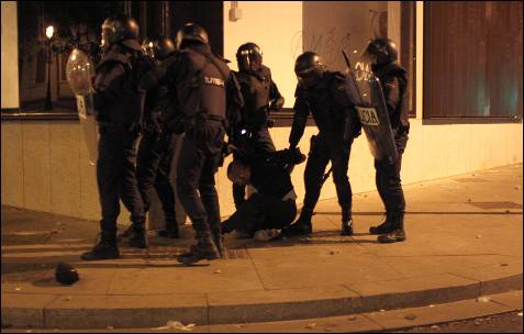 La Policía detiene a una manifestante durante los disturbios en el centro de Madrid tras la manifestación del 22-M.