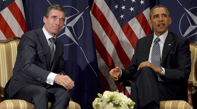 El presidente estadounidense, Barack Obama (dcha), conversa con el secretario general de la OTAN, Anders Fogh Rasmussen (izqda), en la sede de la OTAN en Bruselas.