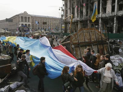 Unos ciudadanos ucranianos sostienen una bandera gigante hecha con tres banderas, la de Ucrania, la de Crimea y la de los tártaros de crimea, en la plaza de la Independencia de Kiev, Ucrania.