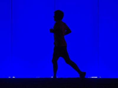 Una persona corre por la vuelta del Castillo de Pamplona, que entre otros edificios públicos de la capital navarra, se ha iluminado esta noche de azul para conmemorar la Semana del Autismo, dentro de una serie de actividades encaminadas a dar a conocer al máximo este síndrome en la sociedad.