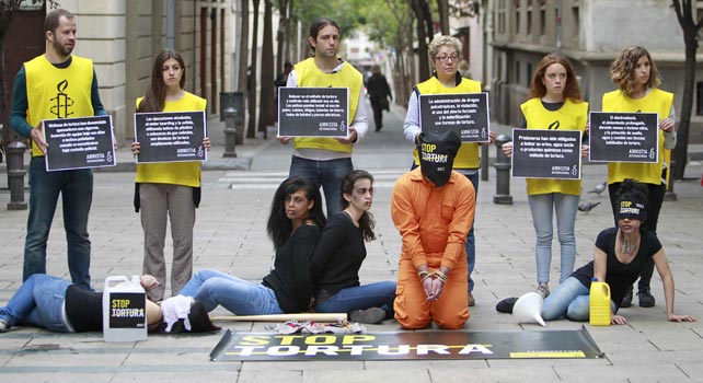 Miembros de Amnistía Internacional durante un acto en Barcelona para escenificar a las víctimas de la tortura, para presentar la campaña 'Stop Tortura'.