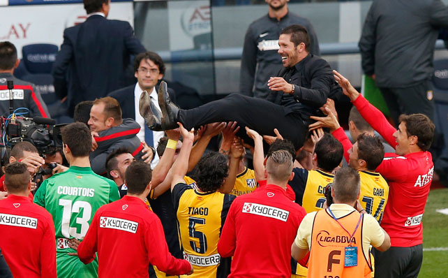 Los jugadores del Atlético mantean a Simeone al termino del partido.