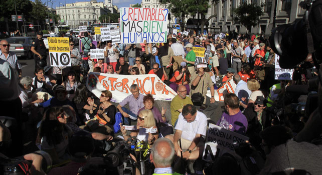 Manifestantes del 15-M en una sentada en la Calle Alcalá durante la marcha.