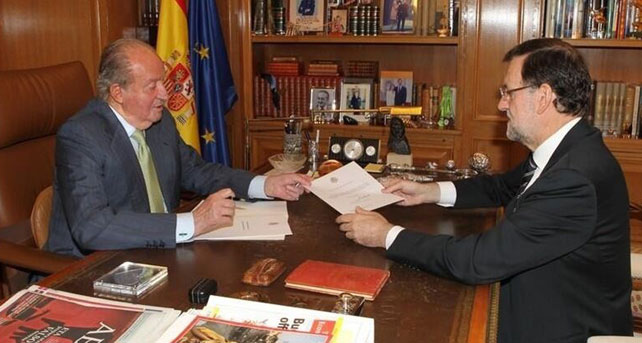 Fotografía publicada por la Casa Real en Twitter el momento en el que el rey entrega a Rajoy el documento de su abdicación.