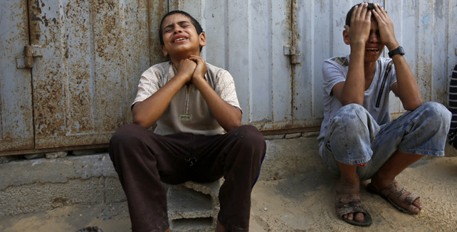 Dos niños lloran junto a los escombros de su casa tras un ataque aéreo de Israel al este de la ciudad de Khanyounis, al sur de la Franja de Gaza.