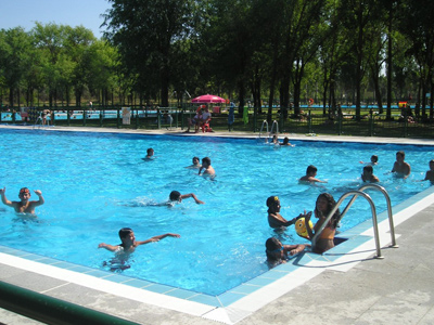 Niños bañándose en una piscina pública.