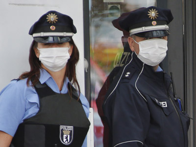 Agentes de policía, protegidos con máscaras, aislaron una oficina de empleo de Berlín ante la sospecha de un caso de ébola, que resultó ser una diarrea.