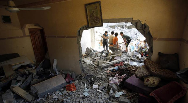 Niños palestinos juegan entre los escombros de su viviendas destruidas tras varios ataques aéreos sobre la ciudad de Rafah