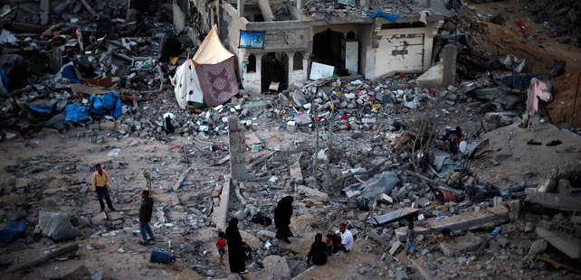 Una familia gazatí, entre los escombros de su casa destruida por bombas israelíes. REUTERS/Suhaib Salem