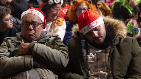 Dos personas dormidas durante la celebración del Sorteo Extraordinario de la Lotería de Navidad 2024, en el Teatro Real