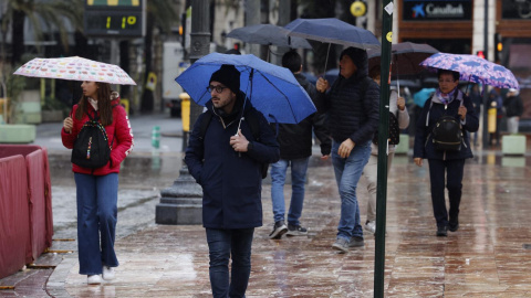 Algunas personas caminan bajo la lluvia en València, a 1 de enero de 2025.