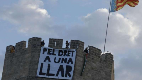 Fotografía de una pancarta colgada en las Torres de Serranos durante una protesta contra los apartamentos turísticos en Valencia.